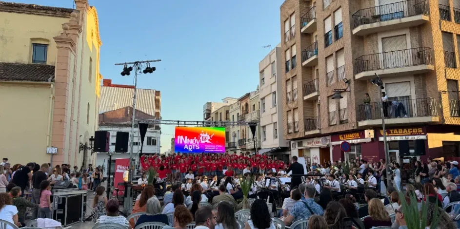 Pantalla LED sobre truss en un concierto al aire libre en una plaza, con coro, orquesta y público