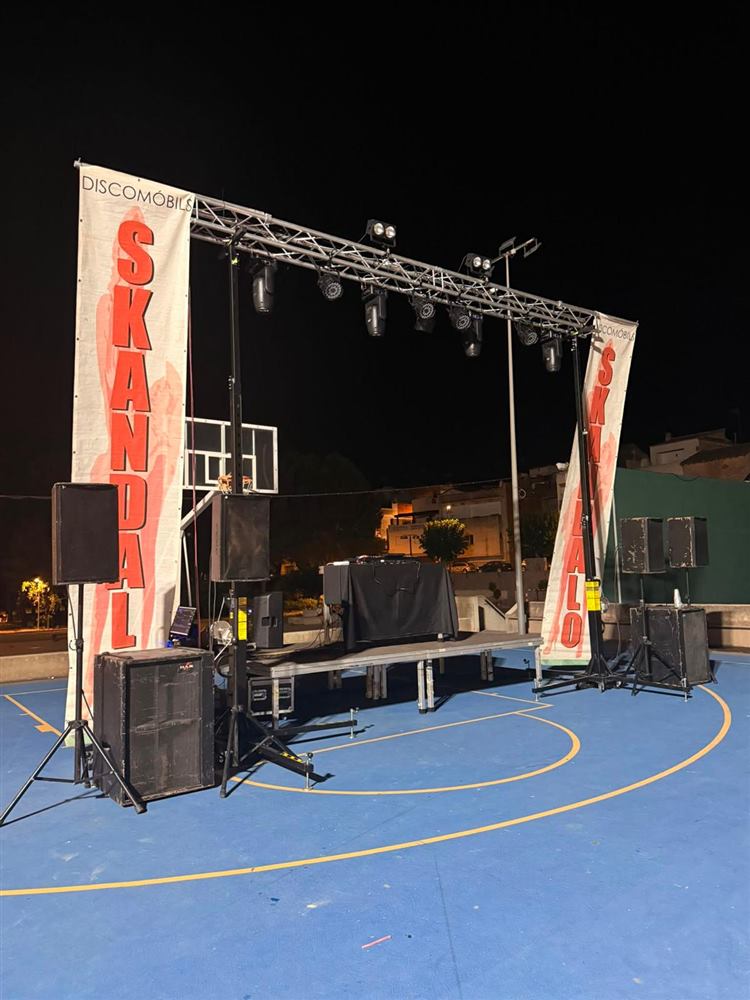 Discomóvil de Skandalo montada de noche en una pista exterior con truss, focos y altavoces